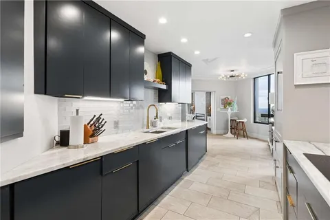 a kitchen with stainless steel appliances a sink dishwasher a refrigerator and cabinets