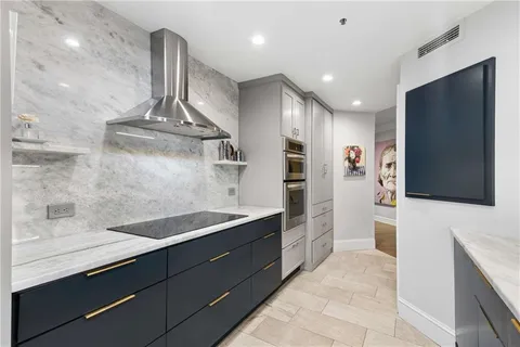 a kitchen with stainless steel appliances kitchen island granite countertop a sink and a refrigerator