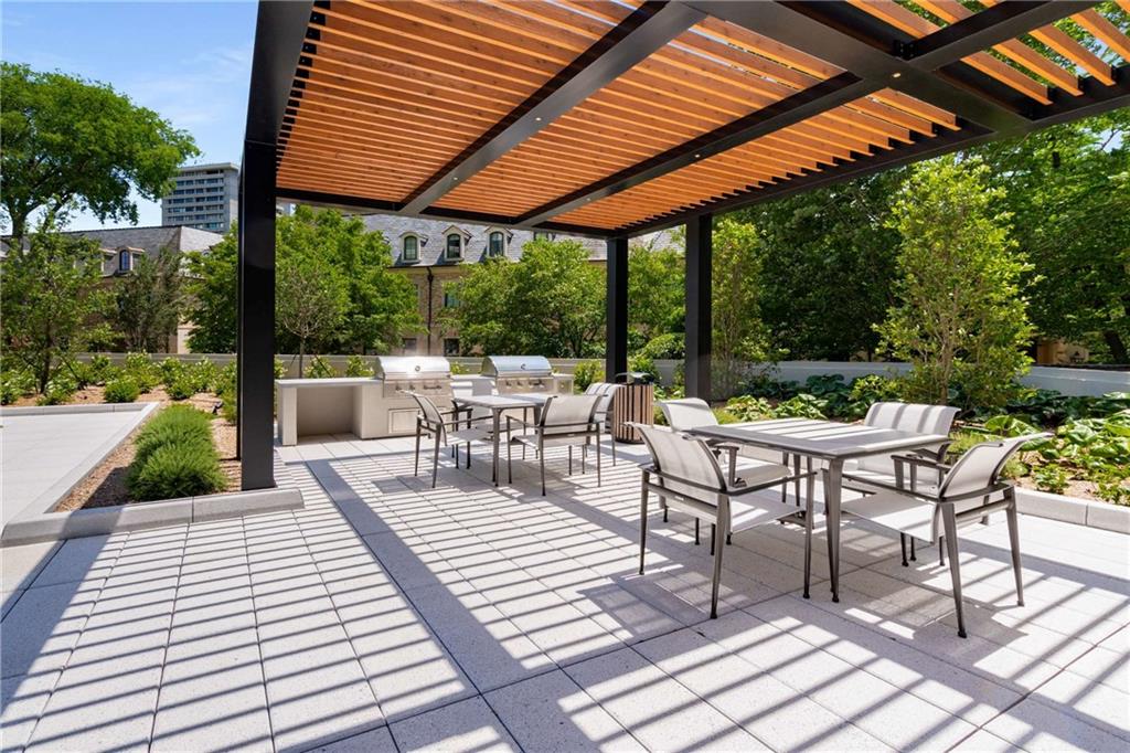 2660 Peachtree Road Northwest, Unit 34F Atlanta, GA 30305 - Photo 49 of 58 a view of a patio with a dining table and chairs with wooden floor and fence