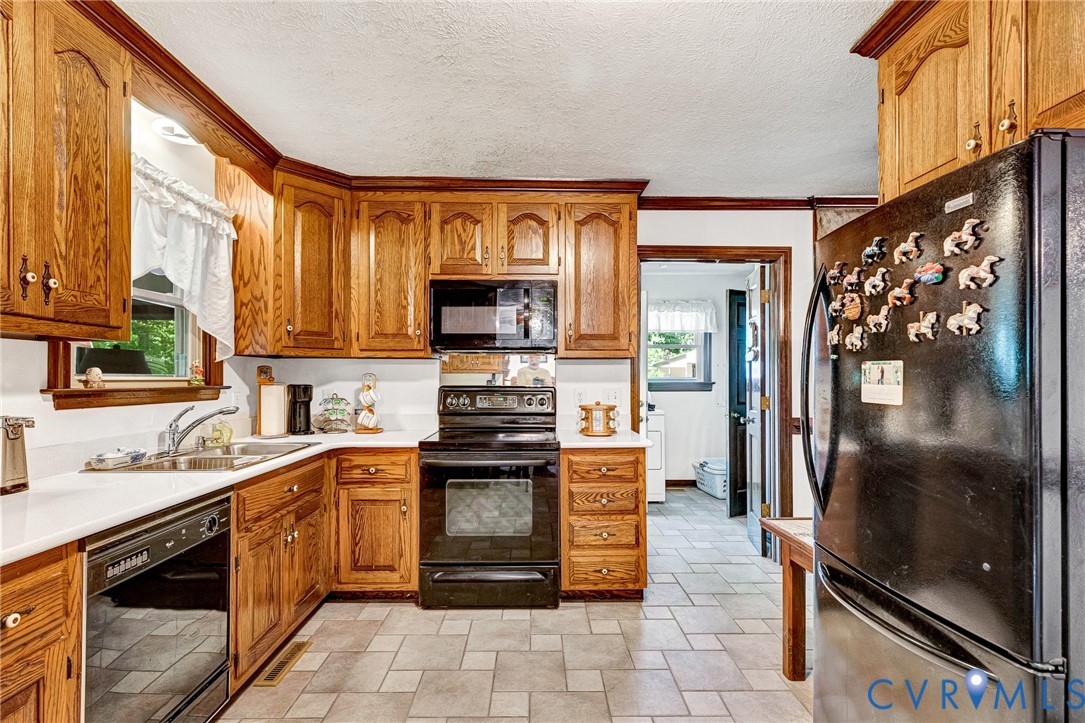 11516 Doswell Road Doswell, VA 23047 - Photo 9 of 50 a kitchen with stainless steel appliances granite countertop a refrigerator a stove and a sink with wooden floor