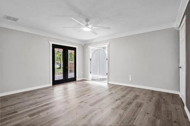 a view of an empty room with wooden floor and a window