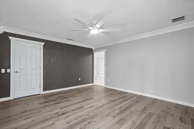 a view of an empty room with wooden floor