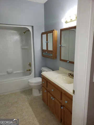 a living room with furniture and a painting on the wall