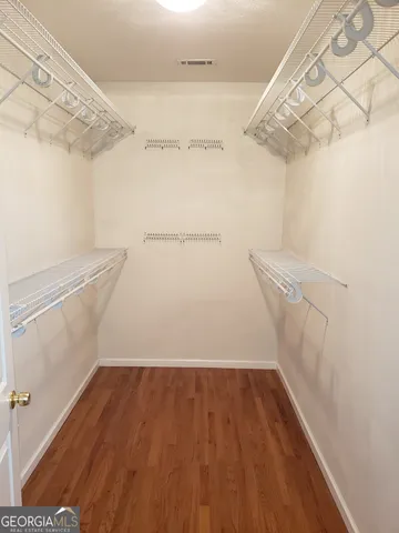 an empty room with chandelier fan and windows