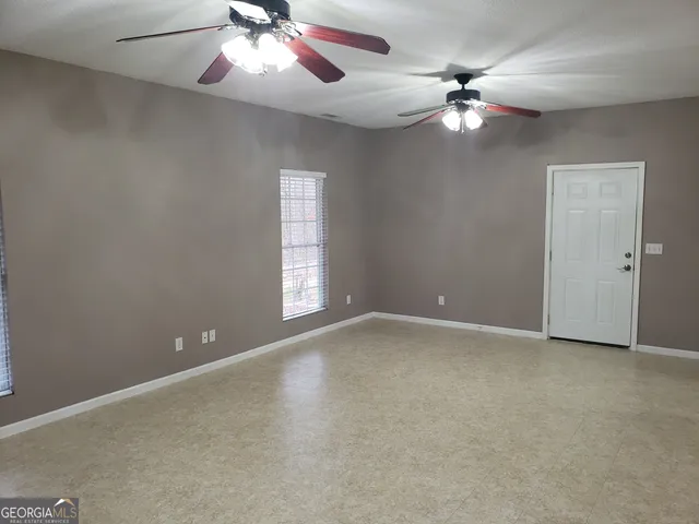 a view of an empty room with a chandelier fan