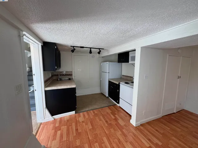 a kitchen with stainless steel appliances kitchen island granite countertop a refrigerator and a sink