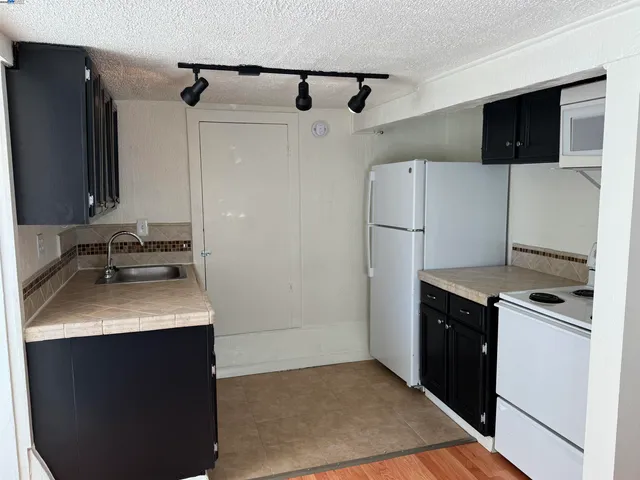 a kitchen with a appliances wooden cabinets and a sink