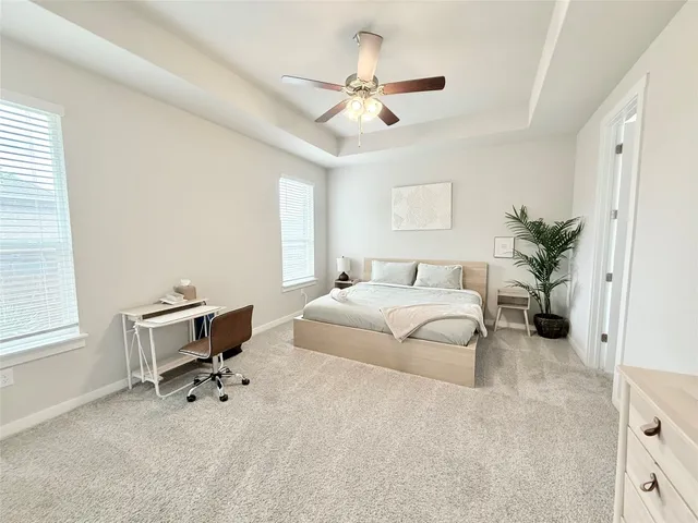 a spacious bedroom with a bed and a chandelier