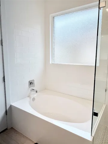 a white bath tub sitting next to a white cabinet