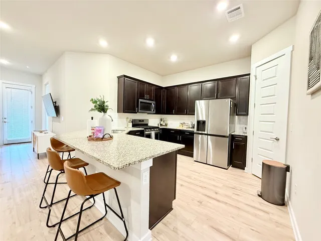 a kitchen with stainless steel appliances a refrigerator and a dining table
