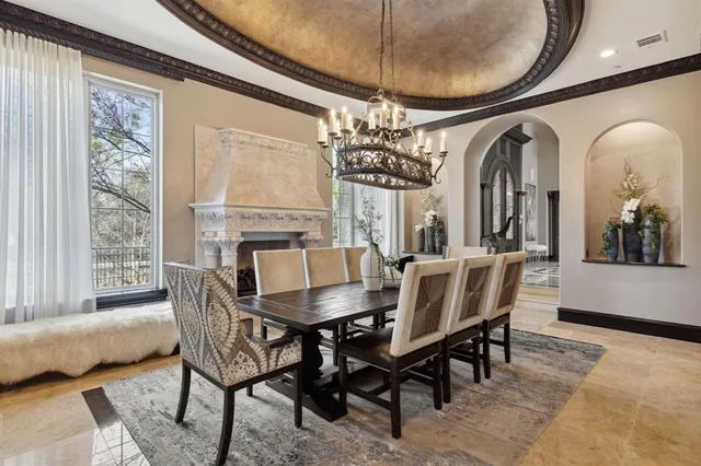 a living room with furniture a fireplace and a chandelier