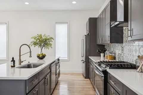 a kitchen with stainless steel appliances a sink stove and cabinets