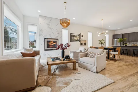 a living room with furniture kitchen view and a chandelier