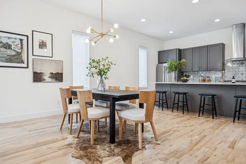 a dining room with furniture potted plants and wooden floor