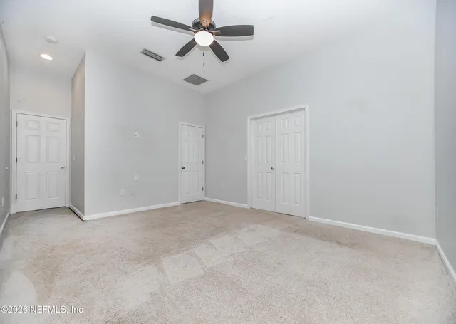an empty room with chandelier fan