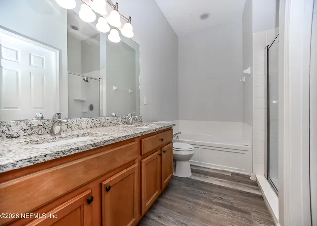 a bathroom with a granite countertop sink a toilet and bathtub