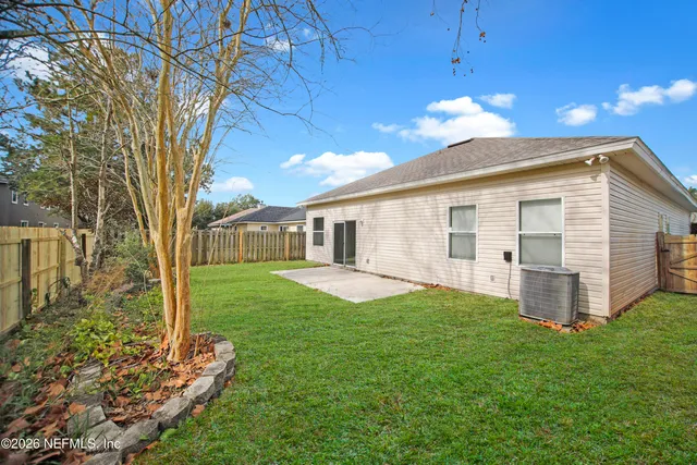 a view of a house with backyard and a tree