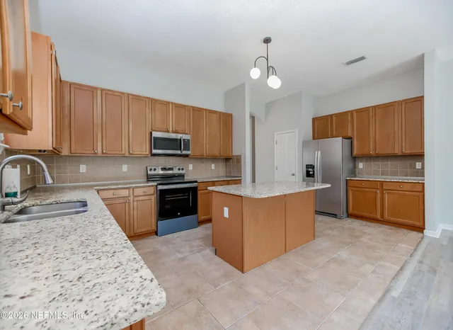 a kitchen with stainless steel appliances granite countertop a stove granite counter tops and a refrigerator