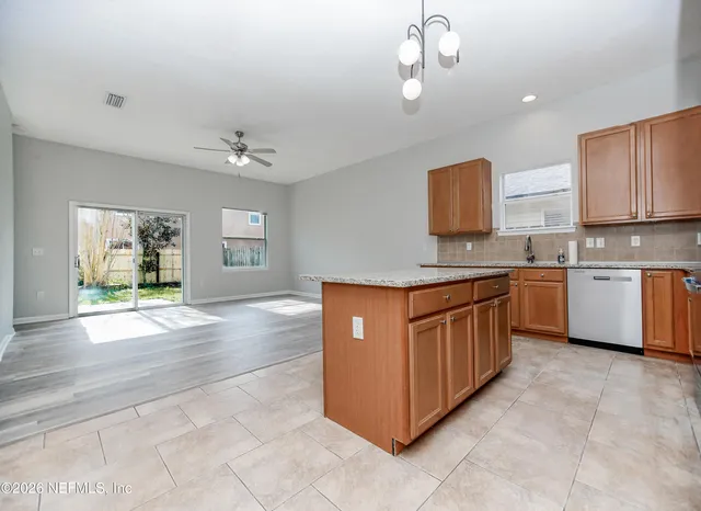 a kitchen with stainless steel appliances granite countertop a stove top oven a sink a counter space and cabinets