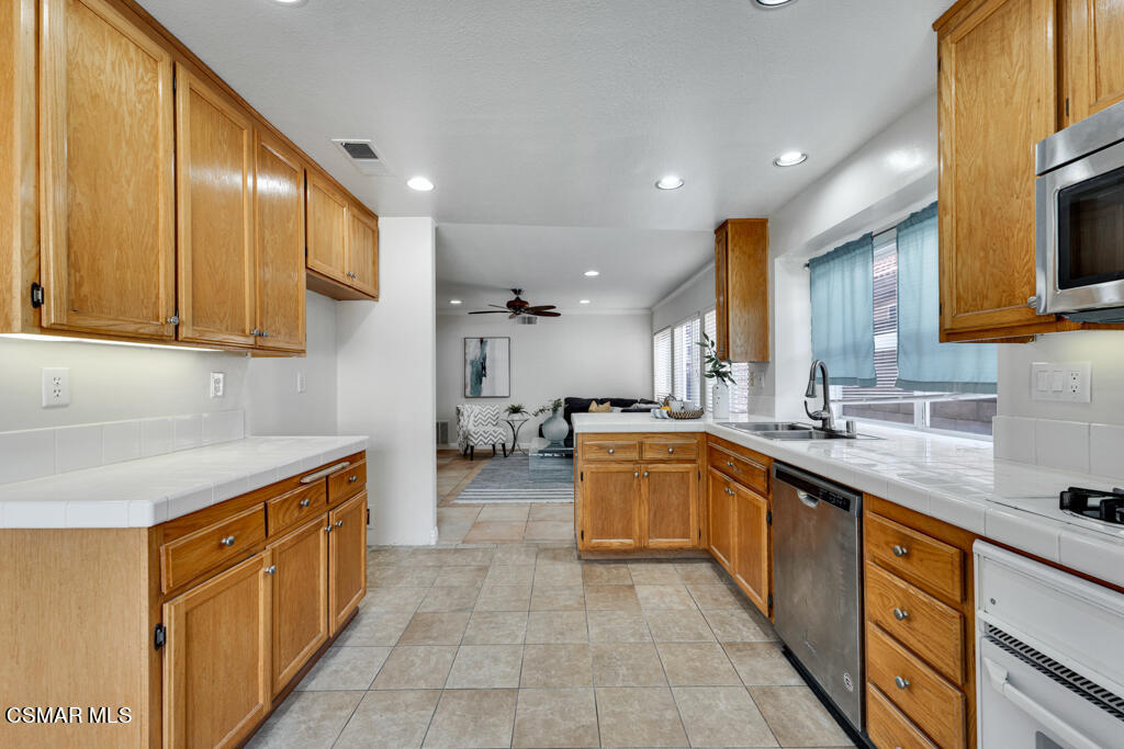 2676 Santa Ynez Avenue Simi Valley, CA 93063 - Photo 12 of 46 a kitchen with stainless steel appliances granite countertop wooden cabinets a sink and dishwasher