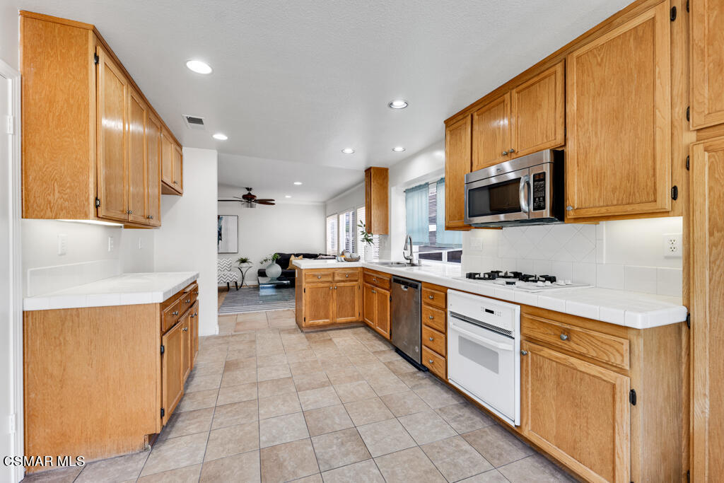 2676 Santa Ynez Avenue Simi Valley, CA 93063 - Photo 13 of 46 a large kitchen with stainless steel appliances granite countertop a stove a sink and a microwave