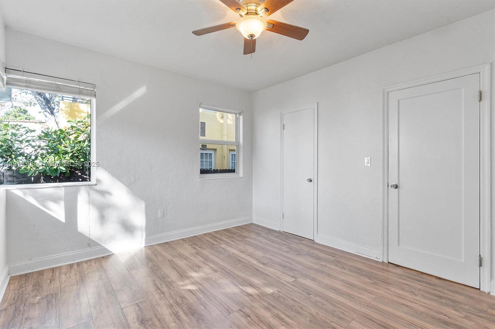 7510 Byron Avenue, Unit 8 Miami Beach, FL 33141 - Photo 8 of 15 a view of an empty room with wooden floor and a window