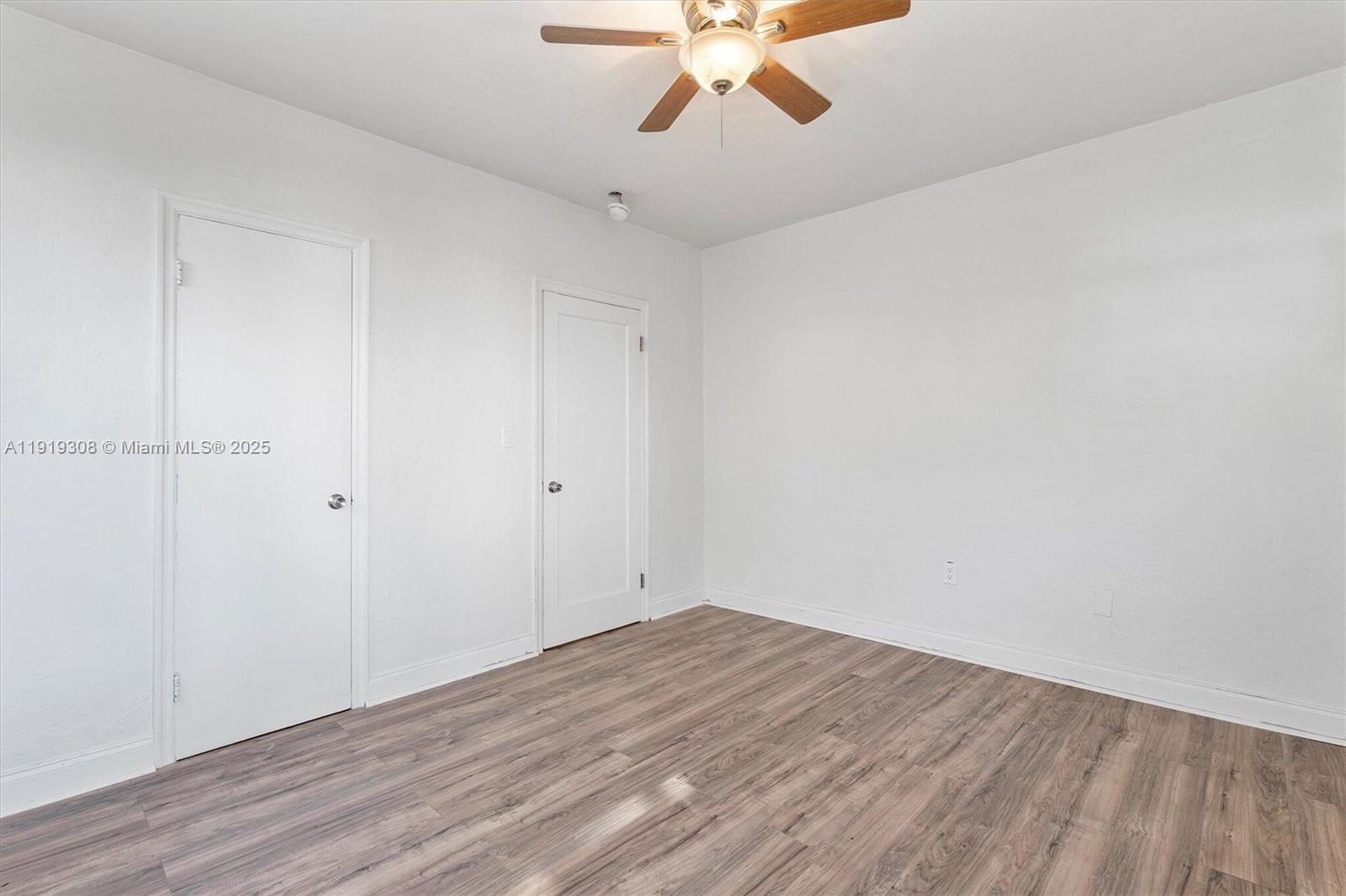 7510 Byron Avenue, Unit 8 Miami Beach, FL 33141 - Photo 9 of 15 a view of a room with wooden floor and a ceiling fan