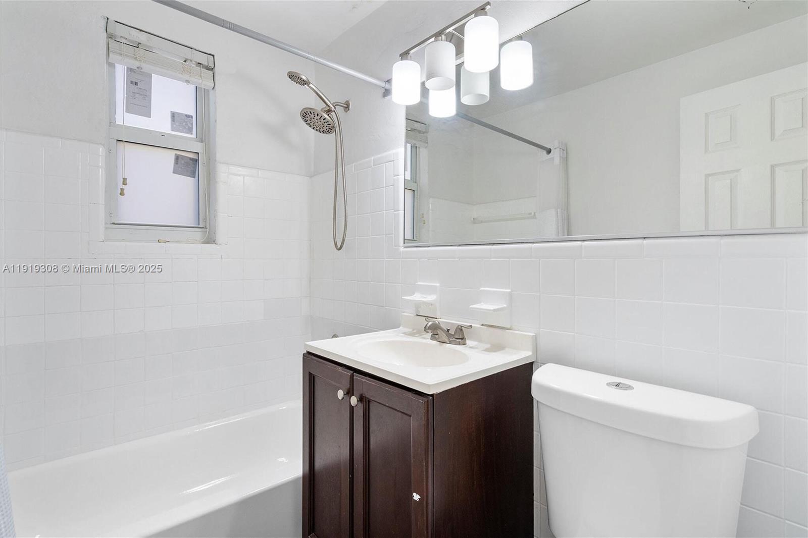 7510 Byron Avenue, Unit 8 Miami Beach, FL 33141 - Photo 10 of 15 a bathroom with a sink a toilet and shower