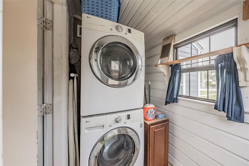 1802 Keneipp Road Carrollton, TX 75006 - Photo 17 of 22 This utility area features a stacked washer and dryer, a window with curtains, and white paneled walls