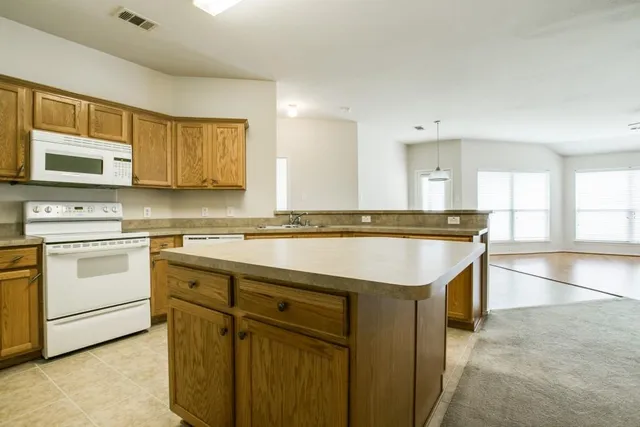 a kitchen with granite countertop a sink stainless steel appliances and cabinets