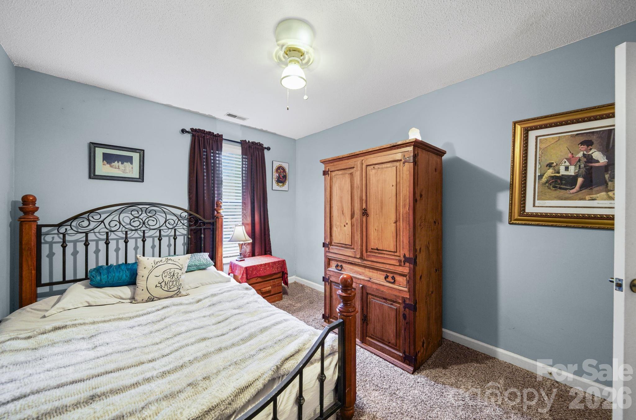 2788 Red Bud Lane Fort Mill, SC 29715 - Photo 21 of 35 a bedroom with a bed and a chandelier