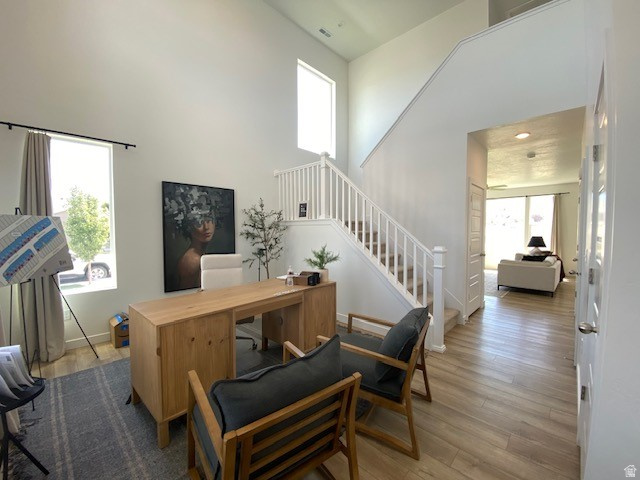 341 Quartz Road, Unit 8037 Tooele, UT 84074 - Photo 7 of 10 Two-story foyer featuring wood-finish flooring, a white spindle staircase, and abundant natural light from multiple windows