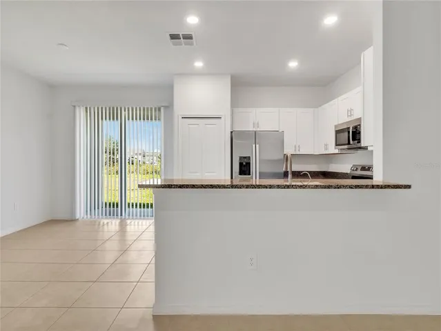 a kitchen with stainless steel appliances a refrigerator and a stove top oven
