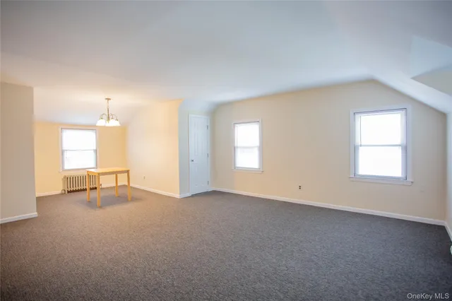 an empty room with windows and ceiling fan