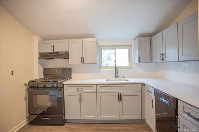 a kitchen with cabinets appliances a sink and a window