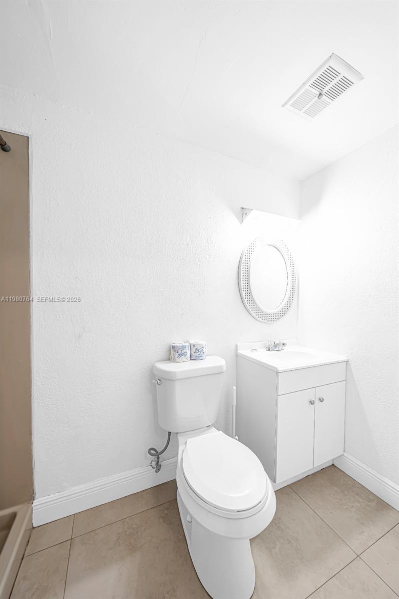 1044 Southwest 13th Court, Unit 2 Miami, FL 33135 - Photo 11 of 17 a bathroom with a sink a toilet and a mirror