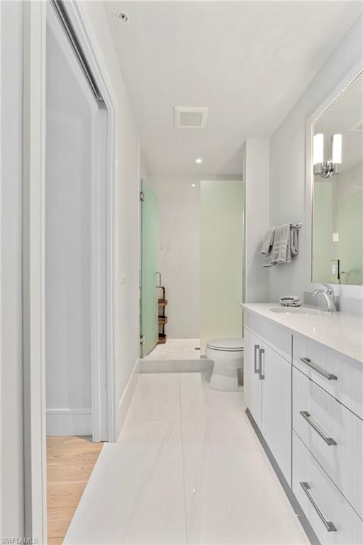 101 8th Street South, Unit 201 Naples, FL 34102 - Photo 12 of 21 a spacious bathroom with a double vanity sink toilet mirror and bathtub