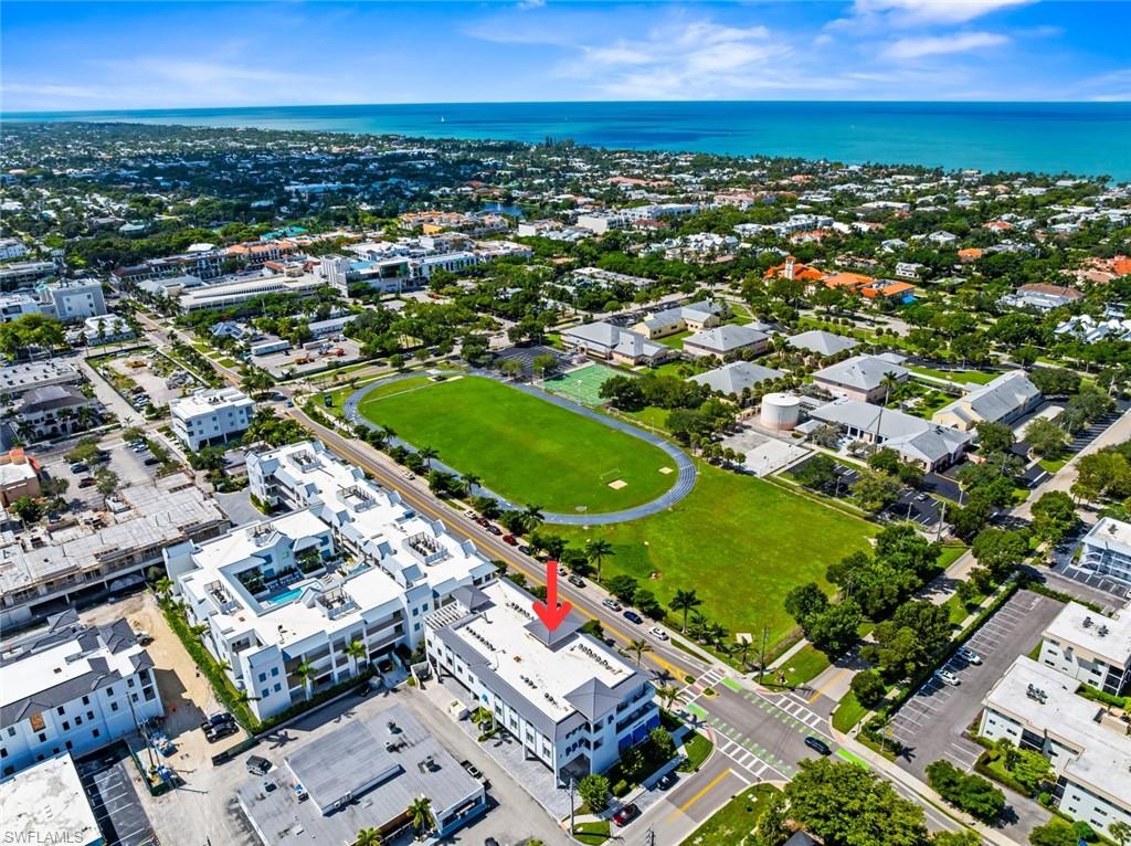 101 8th Street South, Unit 201 Naples, FL 34102 - Photo 20 of 21 an aerial view of a city with lots of residential buildings and mountain view in back