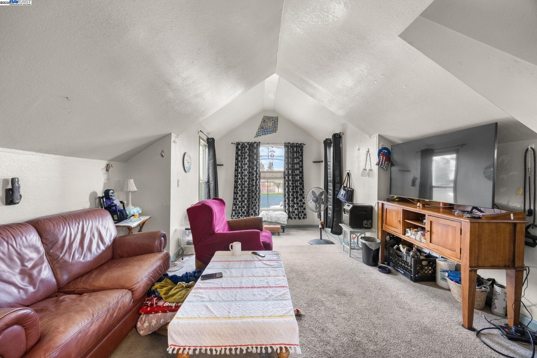 2421 West Rumble Road Modesto, CA 95350 - Photo 16 of 25 a living room with furniture a flat screen tv and a large window