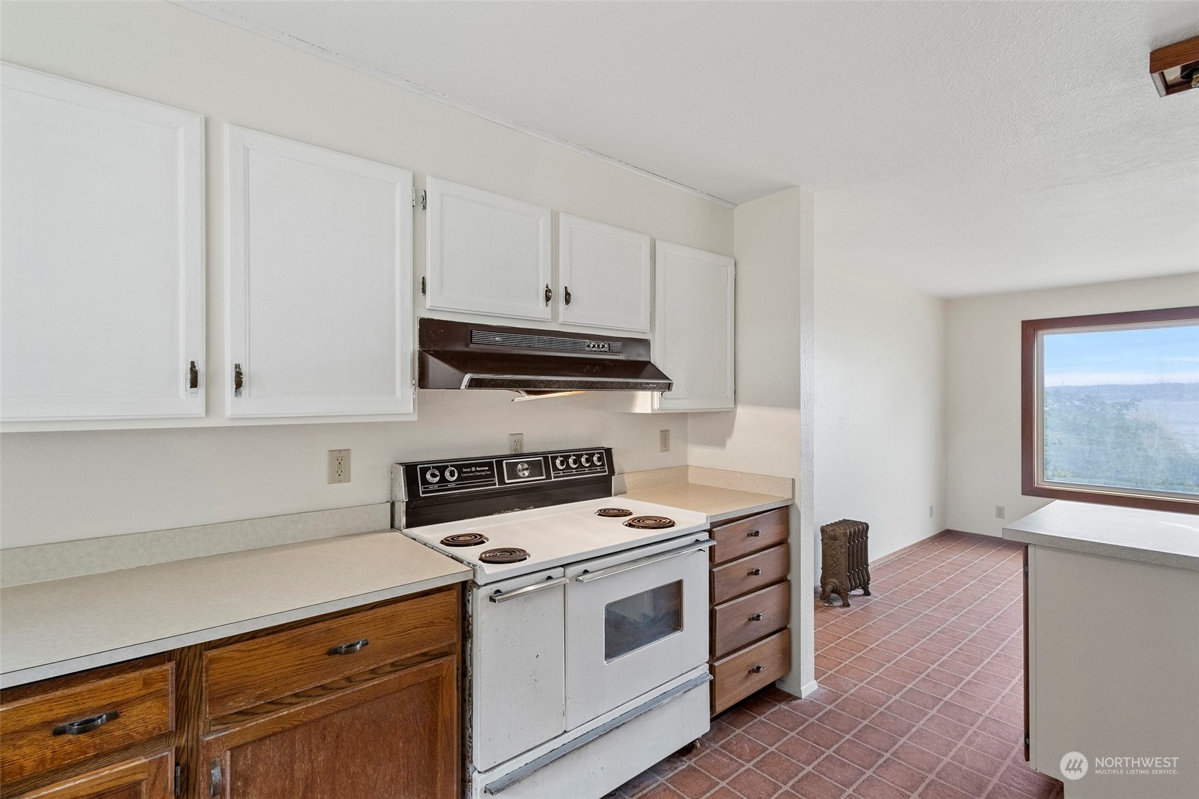 4865 Saratoga Road Langley, WA 98260 - Photo 16 of 40 a kitchen with white cabinets and white appliances