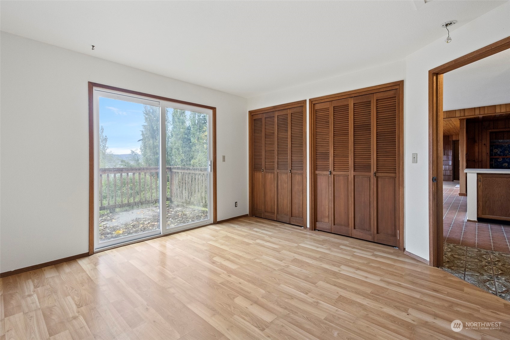 4865 Saratoga Road Langley, WA 98260 - Photo 21 of 40 an empty room with wooden floor and sliding door