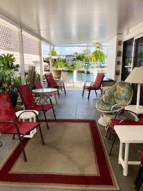 55 Boca Chica Road, Unit 132 Key West, FL 33040 - Photo 16 of 54 a living room with patio furniture and a floor to ceiling window