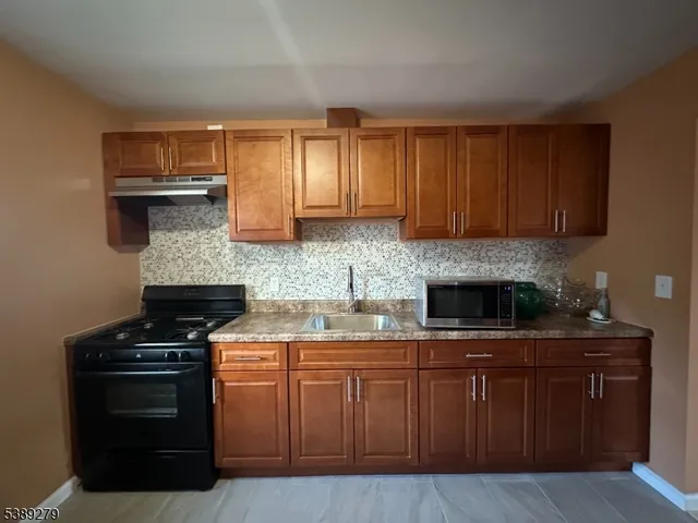 a kitchen with stainless steel appliances wooden cabinets and a stove top oven