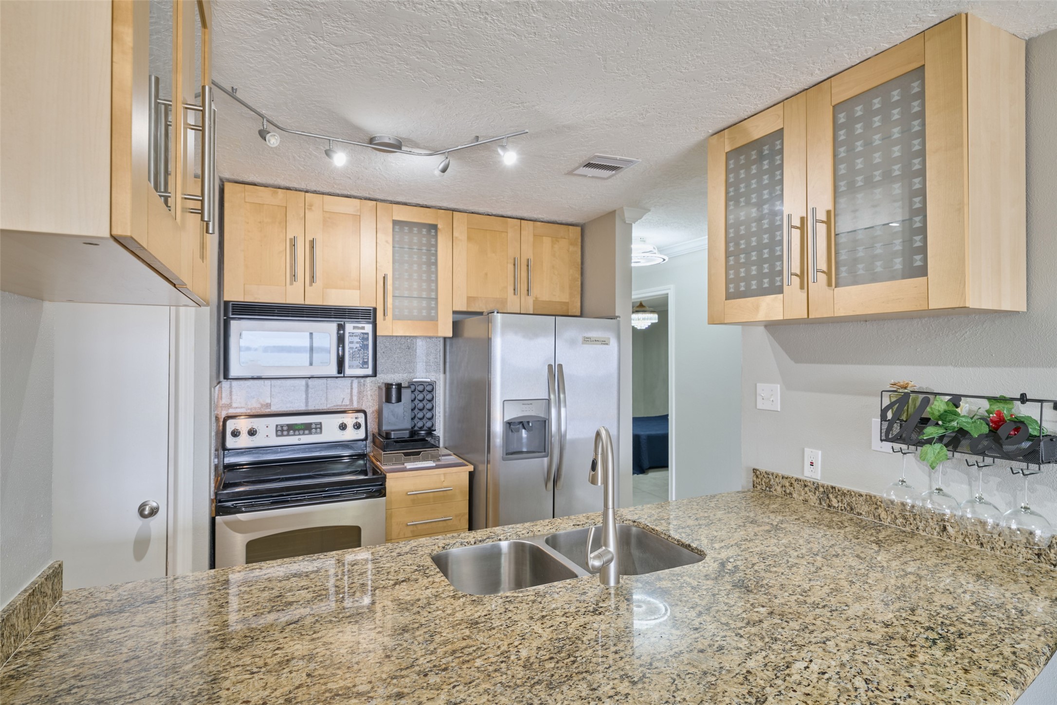 801 River Road, Unit 105D Montgomery, TX 77356 - Photo 12 of 32 a kitchen with stainless steel appliances granite countertop a refrigerator a stove and a sink