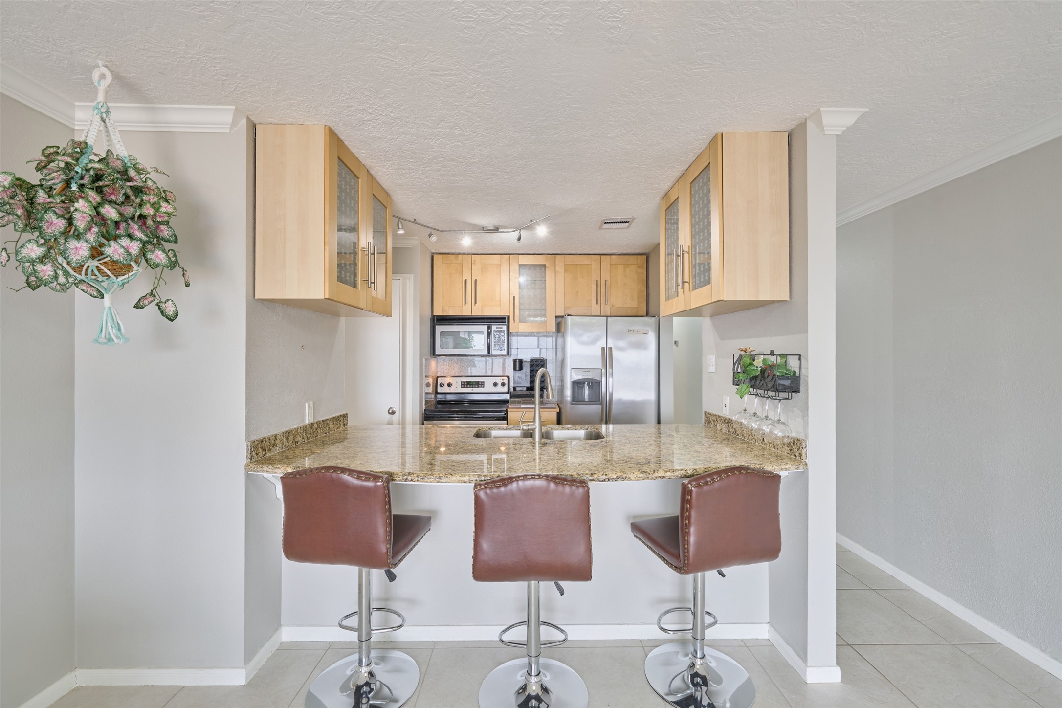 801 River Road, Unit 105D Montgomery, TX 77356 - Photo 10 of 32 a kitchen with stainless steel appliances kitchen island granite countertop a refrigerator and a stove top oven