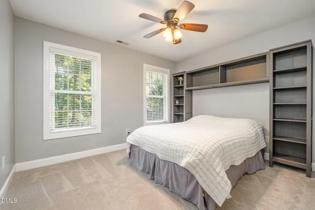 a bedroom with a large bed and a chandelier