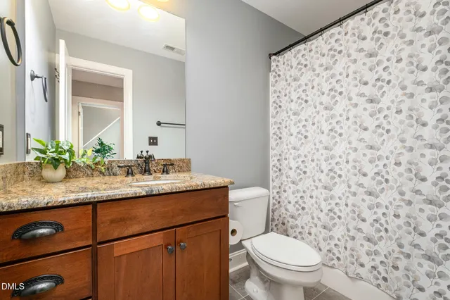 a bathroom with a granite countertop sink a toilet and a mirror