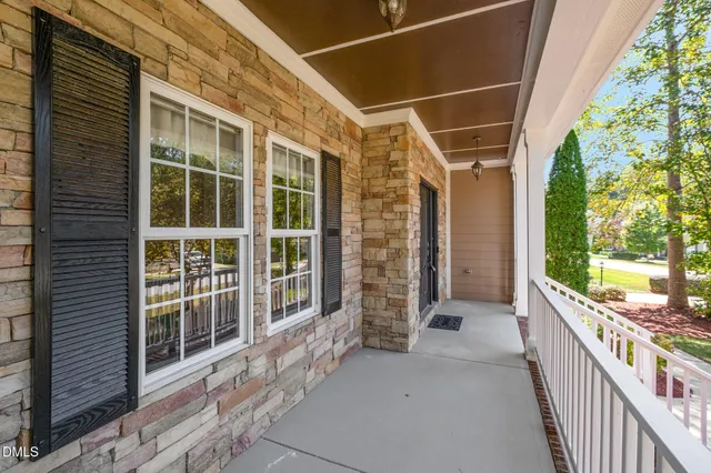a view of a porch with wooden floor and roof with a garden view