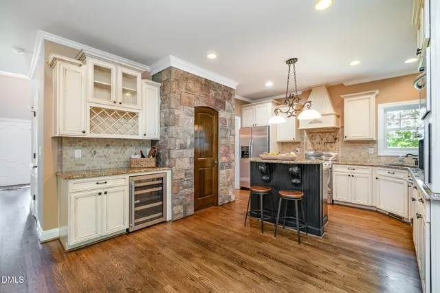 a kitchen with kitchen island granite countertop a sink cabinets and stainless steel appliances