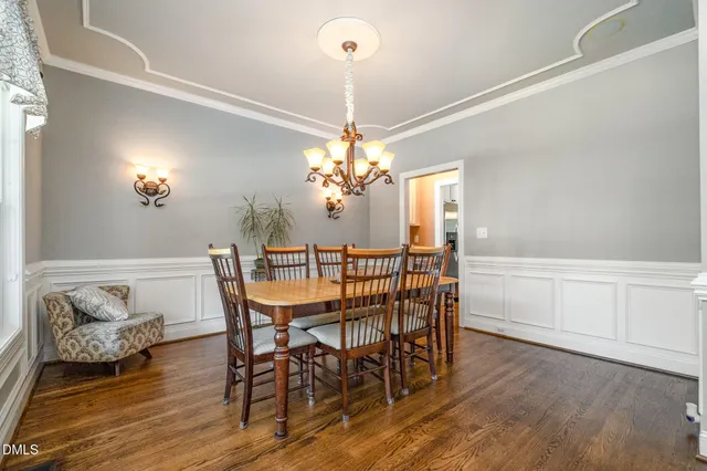 a dining room with furniture a chandelier and wooden floor